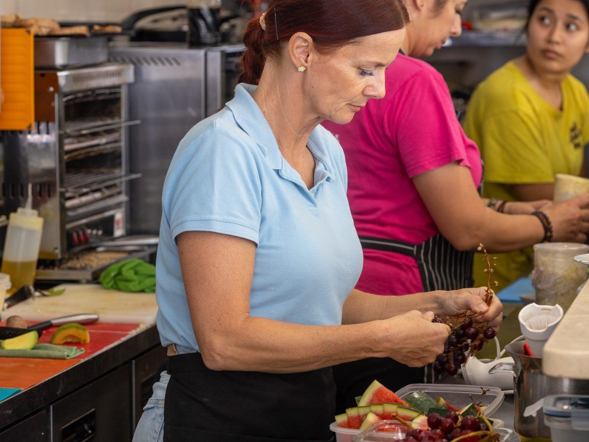 Two cooks plating a dish in the Café Nomad kitchen.